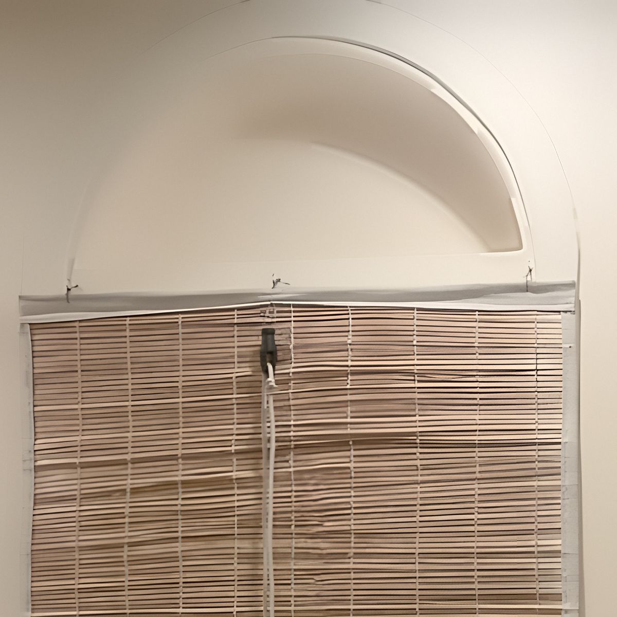 A bamboo blind under a plastered arch